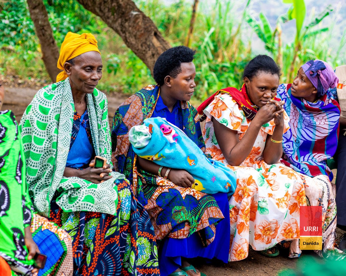 three women with colourful outfits sitting on a bench attending a training